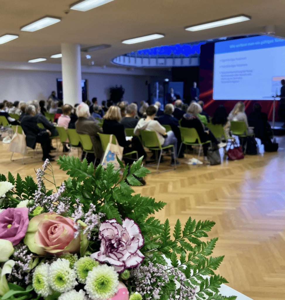 a group of people in a room with a large screen
